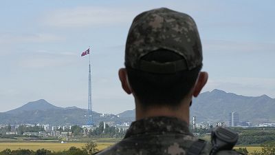 A North Korean flag flutters in the wind as a South Korean army soldier stands guard at the border villages of Panmunjom in Paju, South Korea, in October 2022