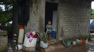 Un niño se encuentra en el porche de su casa que está rodeada por las aguas tras el huracán Orlene en la Isla del Bosque, México