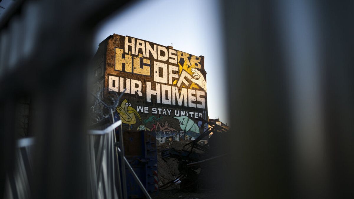 Ein Graffiti mit dem Slogan "Hände weg von unseren Häusern" an der Hauswand eines alternativen Wohnprojekts in Berlin