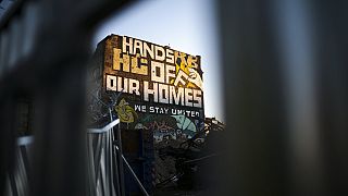 Ein Graffiti mit dem Slogan "Hände weg von unseren Häusern" an der Hauswand eines alternativen Wohnprojekts in Berlin