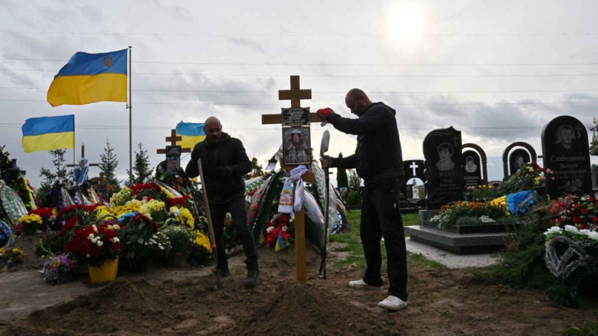  يضع عمال البلدية صليباً على قبر ميخايلو ماتيوشينكو، الذي قُتل في الجو فوق البحر الأسود في 26 يونيو 2022
