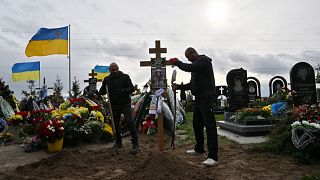  يضع عمال البلدية صليباً على قبر ميخايلو ماتيوشينكو، الذي قُتل في الجو فوق البحر الأسود في 26 يونيو 2022