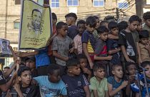 أطفال في غزة يحملون صورة للقائد السابق في حركة الجهاد الإسلامي خالد منصور الذي قتل بغارة إسرائيلية في آب/أغسطس الماضي