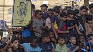 أطفال في غزة يحملون صورة للقائد السابق في حركة الجهاد الإسلامي خالد منصور الذي قتل بغارة إسرائيلية في آب/أغسطس الماضي