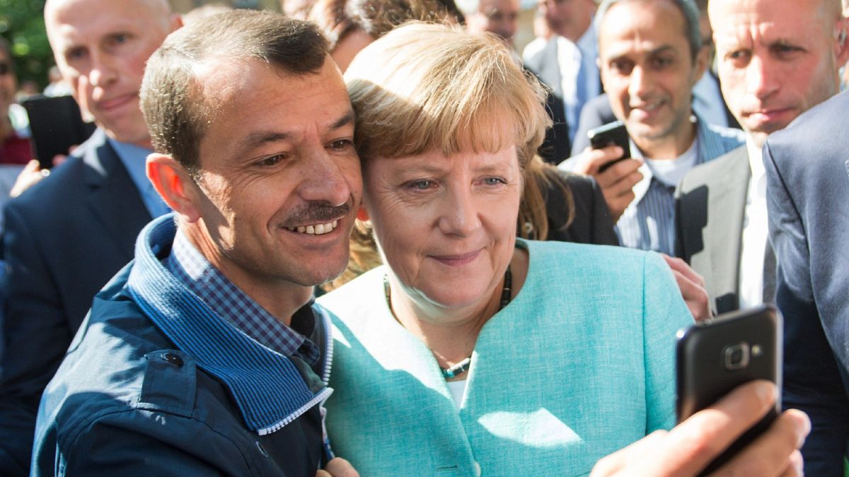 In this Sept. 9, 2015 file photo German chancellor Angela Merkel poses for a selfie with a refugee in a facility for arriving refugees in Berlin. 