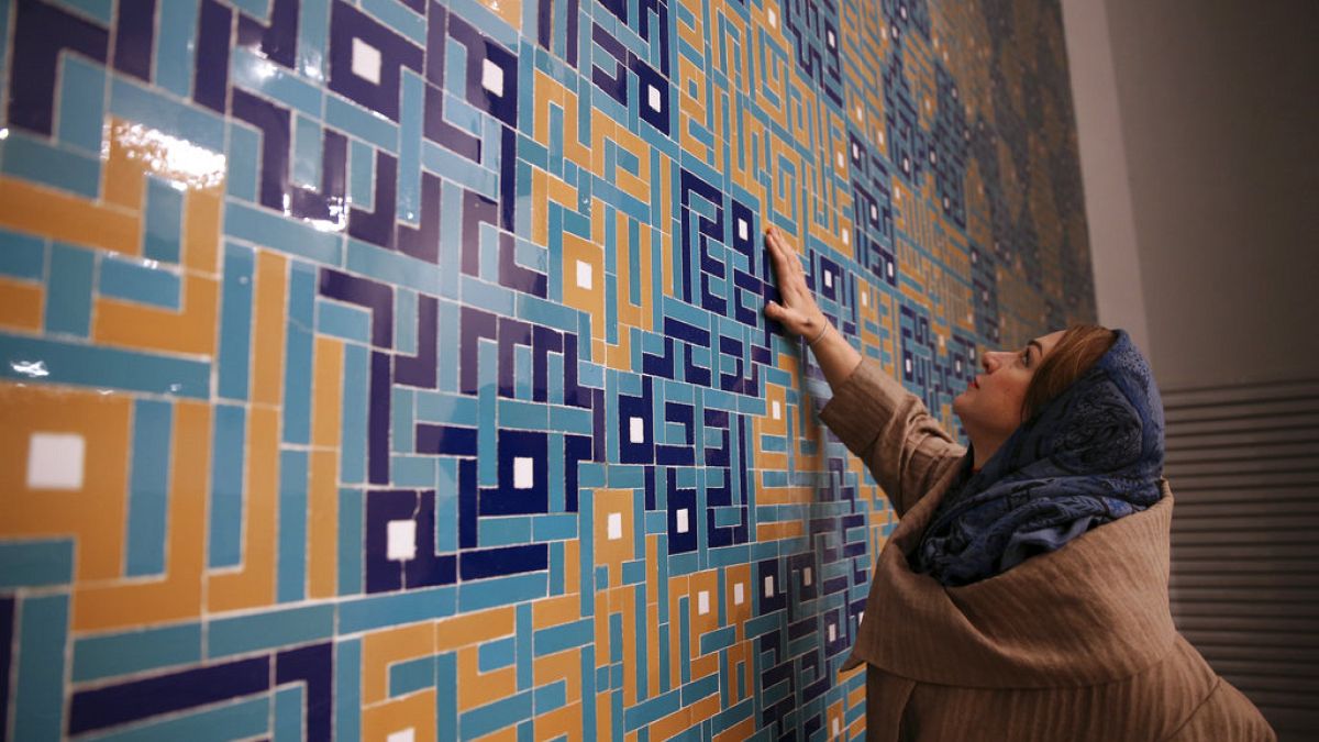  كاترين سبيريدونوف، مهندسة معمارية مشتركة لمسجد ولي العصر تلامس البلاط الملون الذي يزين محراب المسجد، في طهران، إيران، في 7 فبراير 2018 