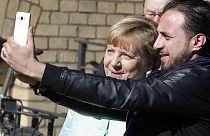 Almanya Başbakanı Angela Merkel 10 Eylül 2015'te Suriyeli mülteci Rodin Saouan ile Berlin'de selfie çektirirken/Arşiv