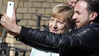 Almanya Başbakanı Angela Merkel 10 Eylül 2015'te Suriyeli mülteci Rodin Saouan ile Berlin'de selfie çektirirken/Arşiv