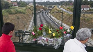 Flowers are placed on a bridge above the railway line at the spot of the train crash.