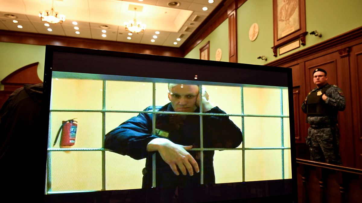 Le chef de l'opposition Alexei Navalny apparaît sur un écran installé dans une salle d'audience du tribunal municipal de Moscou via une liaison vidéo depuis sa prison