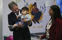 El secretario de Estado de Estados Unidos, Antony Blinken, sostiene a un bebé migrante venezolano durante su visita al Centro de Integración Migratoria en Bogotá, Colombia.