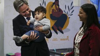 El secretario de Estado de Estados Unidos, Antony Blinken, sostiene a un bebé migrante venezolano durante su visita al Centro de Integración Migratoria en Bogotá, Colombia.