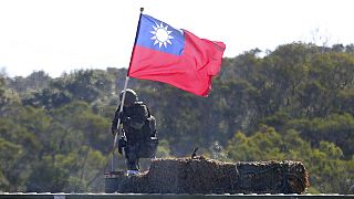 Tayvanlı bir asker, adanın kuzeyinde düzenlenen askeri tatbikat sırasında Tayvan bayrağını tutarken