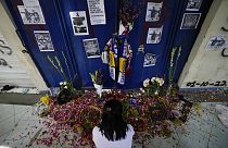 Женщина сидит у мемориала перед воротами стадиона в Маланге. 4 октября 2022.