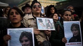 Женщины на демонстрации держат портреты погибшей иранки 