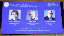 شاشة تعرض صورة الفائزين بجائزة نوبل للكيمياء كارولين بيرتوزي ومورتن ميلدال وباري شاربليس