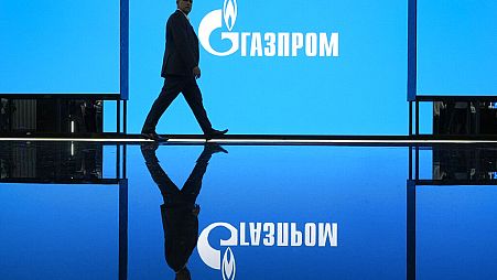 Ein Mann besucht am Mittwoch, 14. September 2022, eine Ausstellung auf dem St. Petersburger Internationalen Gasforum in St. Petersburg, Russland, mit einem Logo des russischen Gasmonopols Gazprom.