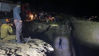 Authorities hoist a migrant up a cliff during a large-scale rescue operation on the island of Kythira, Greece, early Thursday, Oct. 6, 2022.