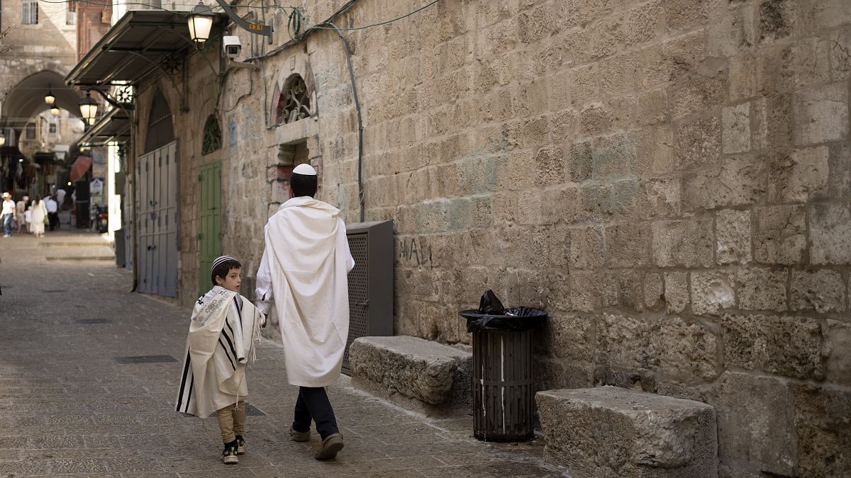 يهودي وابنه يسيران في أزقة البلدة القديمة في القدس في عيد الغفران