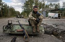 A Ukrainian serviceman smokes a cigarette after he finds and identifies a dead body of a comrade in recently recaptured town of Lyman, Ukraine, Monday, Oct. 3, 2022