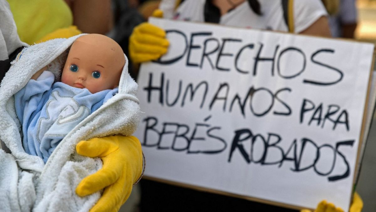 Des manifestants tenant des poupées de bébé et des pancartes sur lesquelles on peut lire "Droits humains pour les bébés volés" à Madrid, le 26 juin 2018.