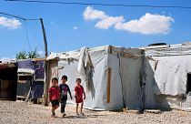 Syrian children walk past their family tents at a refugee camp in the town of Bar Elias, in Lebanon's Bekaa Valley, Tuesday, June 13, 2023. 
