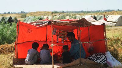 An internally displaced flood-affected family take refuge in a Pakistani refugee camp  on September 28, 2022. 