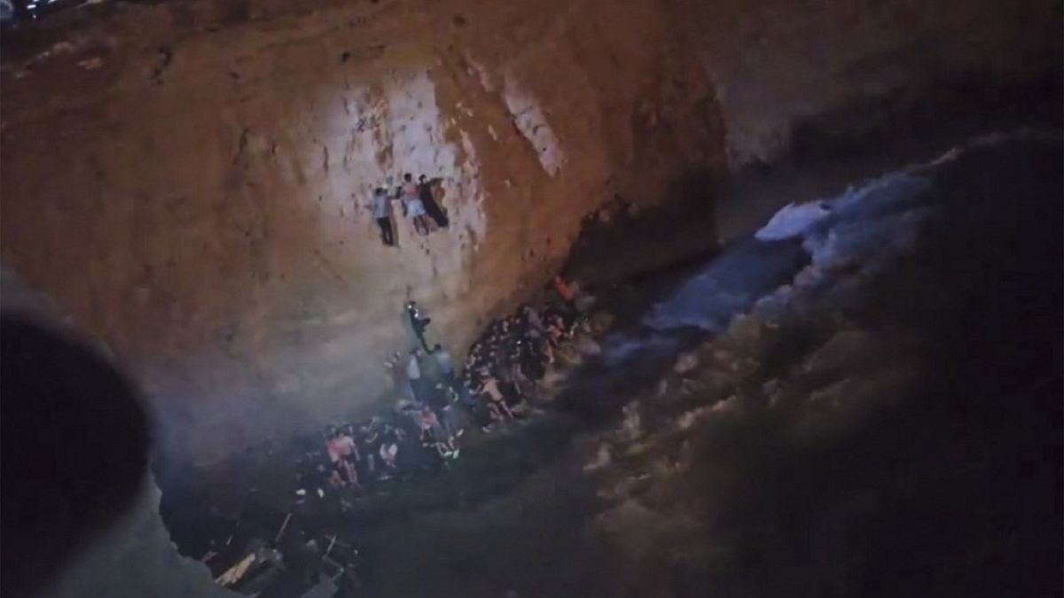 Capture d'écran d'une vidéo des garde-côtes grecs montrant des naufragés en train d'escalader une falaise sur l'île de Cythère - le 06/01/2022