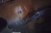 Capture d'écran d'une vidéo des garde-côtes grecs montrant des naufragés en train d'escalader une falaise sur l'île de Cythère - le 06/01/2022