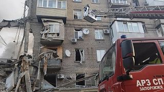 Orosz tüzérségi támadásban megsérült épületnél dolgoznak mentők Zaporizzsjában