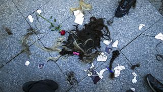 Strands of hair lie on the ground after being cut by several women during a protest against the death of Iranian Mahsa Amini, in Istanbul, Turkey, Sunday, Oct. 2, 2022.