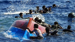  Migrants swim next to their overturned wooden boat during a rescue operation by Spanish NGO Open Arms, Aug. 11, 2022.