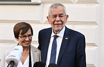 Austria's President Alexander Van der Bellen and his wife Doris speak to the media in front of a polling station in Vienna, in presidential elections on October 9, 2022.