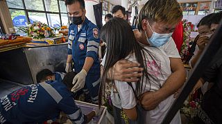 Les parents d'un enfant tué en deuil au temple Wat Rat Samakee dans la ville d'Uthai Sawan, au nord-est de la Thaïlande, dimanche 9 octobre 2022. 