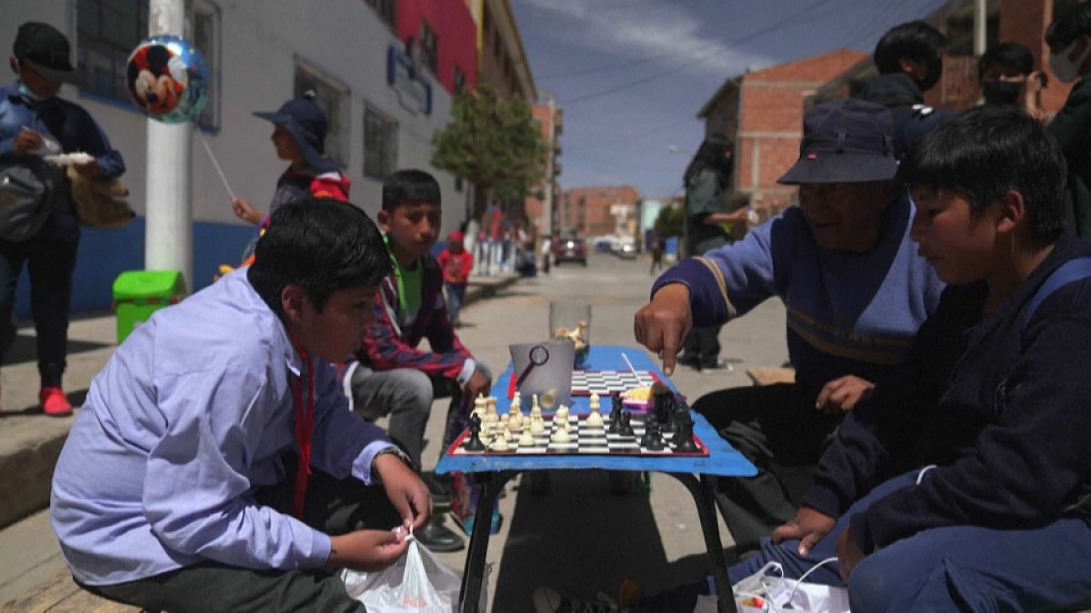 Juan Copa, dueño de una pequeña tienda de artículos de escritorio en El Alto, en Bolivia, enseña ajedrez a los niños.