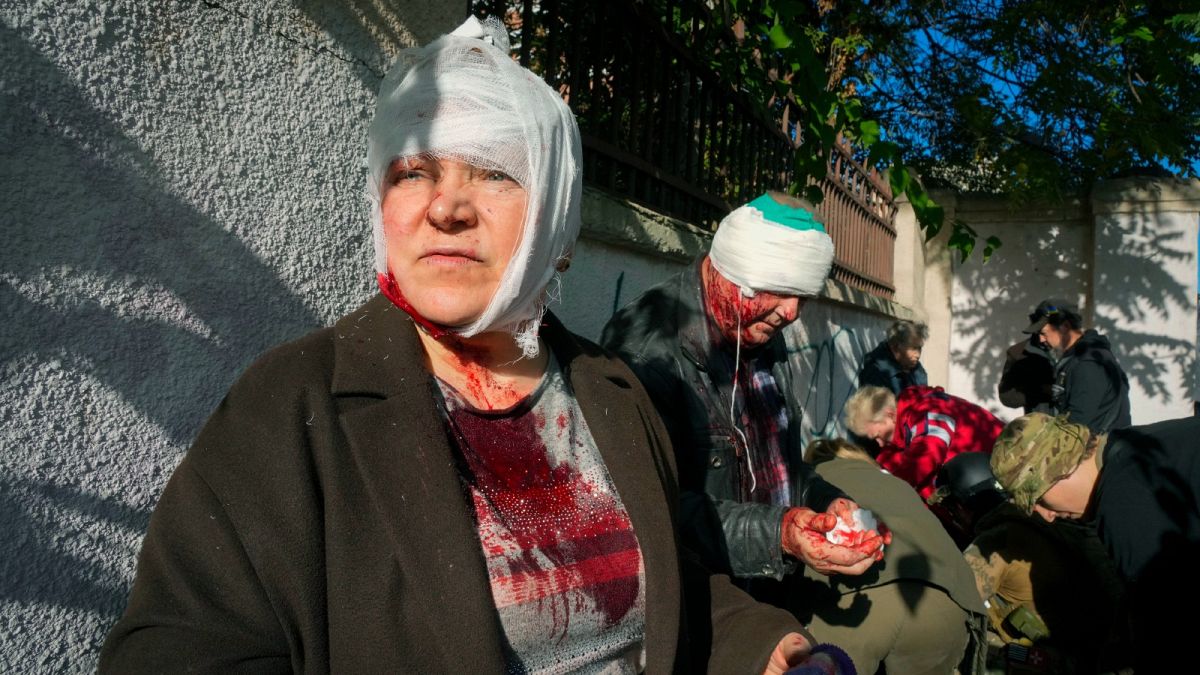 People receive medical treatment at the scene of Russian shelling, in Kyiv, Ukraine, Monday, Oct. 10, 2022.