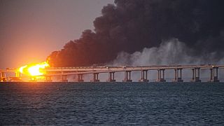 Las llamas y el humo se elevan frente al puente de Crimea que conecta el territorio continental ruso y la península de Crimea sobre el estrecho de Kerch, en Kerch, Crimea