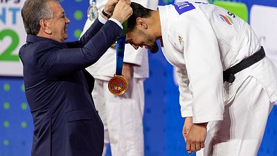 El presidente de Uzbekistán, Shavkat Mirziyoyev, entrega su oro al campeón de -90kg, Davlat Bobonov