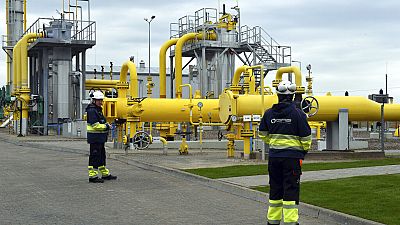 Workers stand near the pipelines during an opening ceremony of the Baltic Pipe in Budno, Poland, Tuesday, Sept. 27, 2022. 