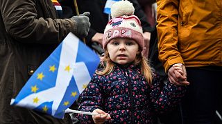 A young pro-independence protester holds a Saltire (Scottish flag) during a March against Boris Johnson in Glasgow on January 22, 2022