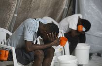 Kolerás tünetekkel küzdő betegek ülnek egy megfigyelőközpontban a haiti Port-au-Prince-ben 2022. október 7-én
