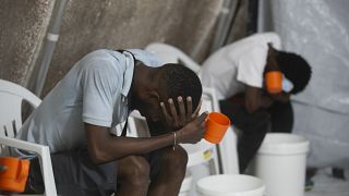 Kolerás tünetekkel küzdő betegek ülnek egy megfigyelőközpontban a haiti Port-au-Prince-ben 2022. október 7-én