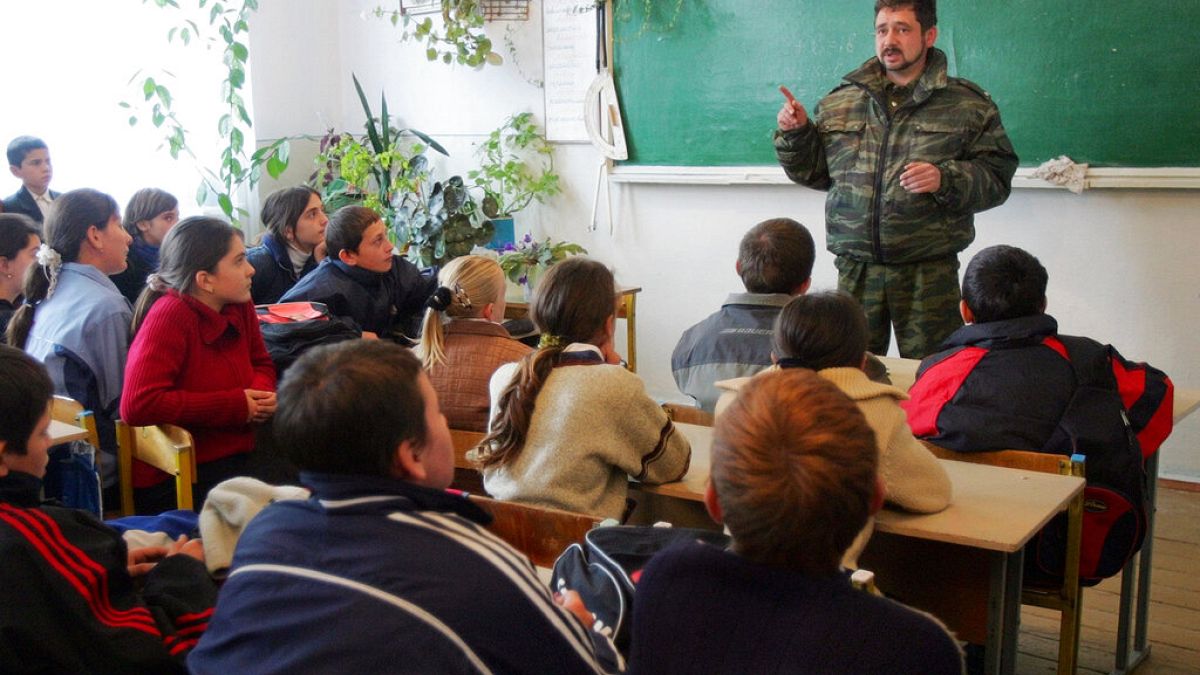 Orosz középiskolások hallgatják egy rendőrtiszt előadását