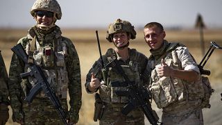 جنود روس وأمريكيون يلتقطون الصور أثناء تقاطع طرق دورياتهم في حقل نفطي بالقرب من بلدة القحطانية السورية، في 8 أكتوبر 2022.