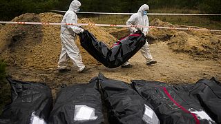 Investigadores forenses ucranianos exumam corpos em Lyman