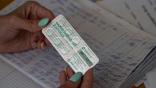 A woman shows a pack with iodine tablets before distributing them to residents at a local school in case of a radiation leak in Zaporizhzhia, Ukraine.