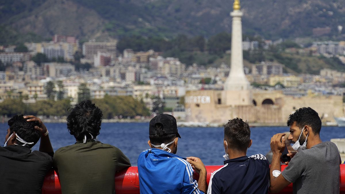 Спасенные с надувных лодок нелегальные мигранты готовятся сойти на землю на Сицилии, Италия. 22 сентября 2022.