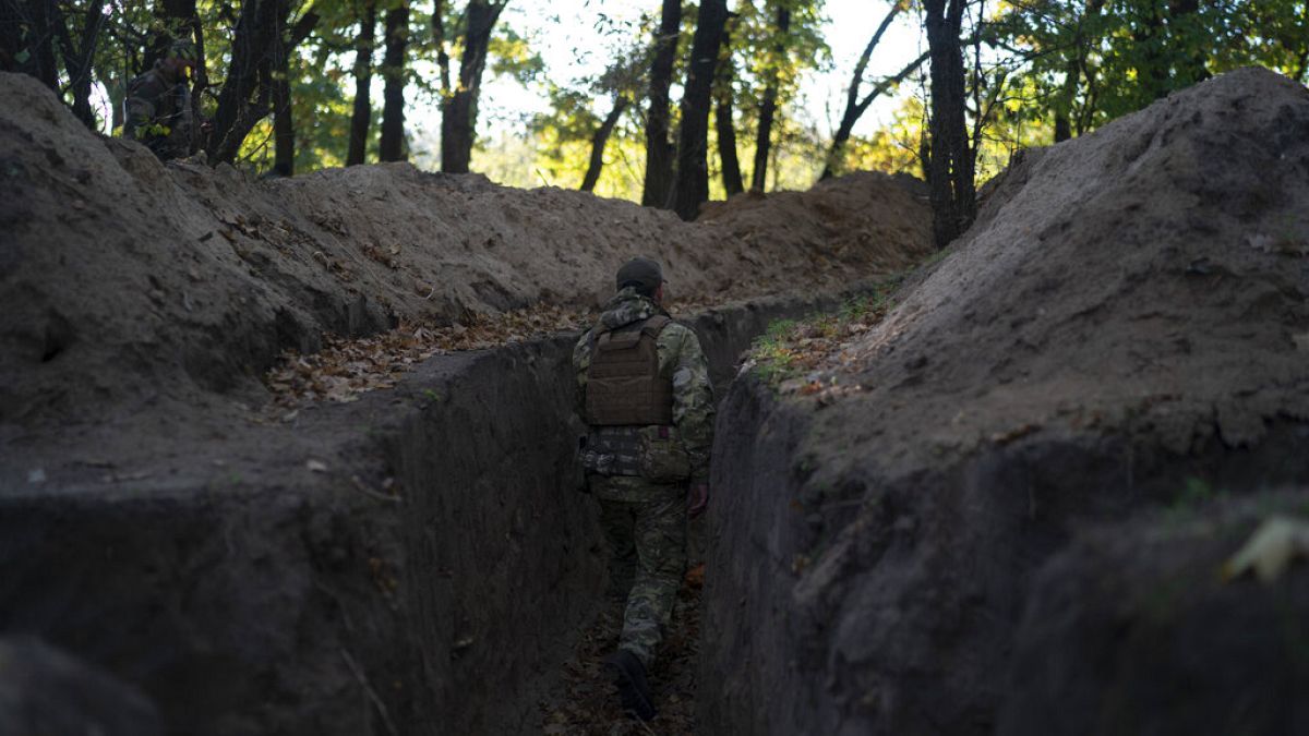 A Ukrainian serviceman checks the trenches dug by Russian soldiers in a retaken area in Kherson region, Ukraine, Wednesday, Oct. 12, 2022