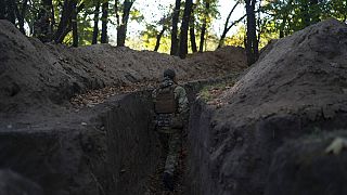 A Ukrainian serviceman checks the trenches dug by Russian soldiers in a retaken area in Kherson region, Ukraine, Wednesday, Oct. 12, 2022