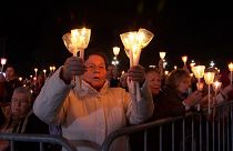Pilgrims holding candles and chanting as the statue of Our Lady of Fatima passes through the crowd.